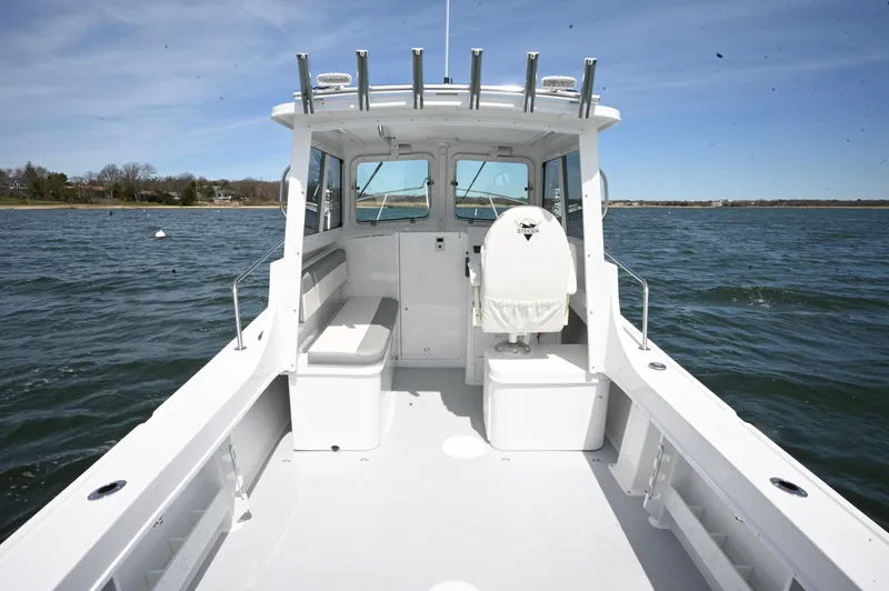 Slide: The Image of 2026 Steiger Craft 23 Miami boat interior on calm water, showcasing seating and helm. - 11