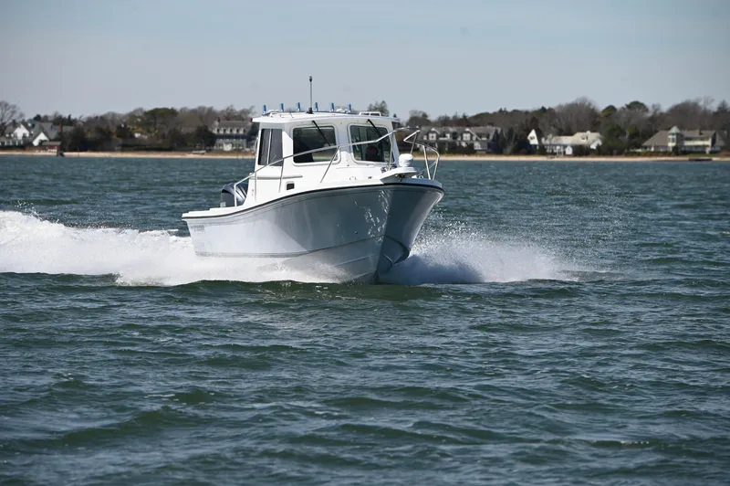 Slide: The Image of 2026 Steiger Craft 23 Miami boat cruising on open water near shoreline. - 6