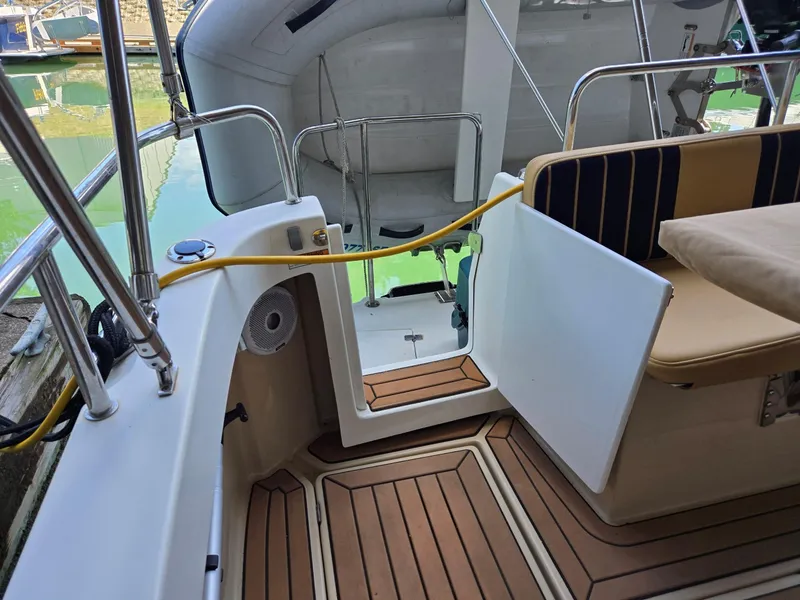 Slide: The Image of 2014 Ranger Tugs R-27 boat interior with teak flooring and cushioned seating. - 13