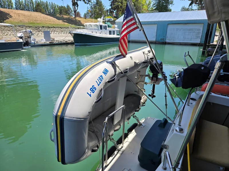Slide: The Image of 2014 Ranger Tugs R-27 with dinghy and American flag at marina. - 15