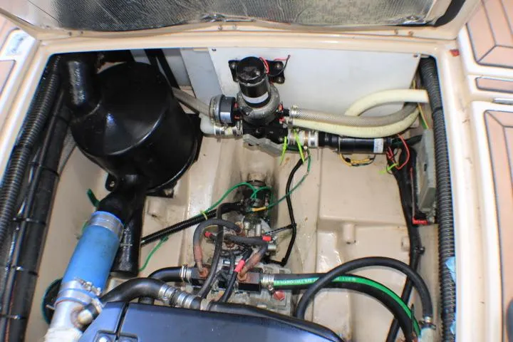 Slide: The Image of Engine compartment of a 2014 Ranger Tugs R-27 boat, showcasing mechanical components and hoses. - 19