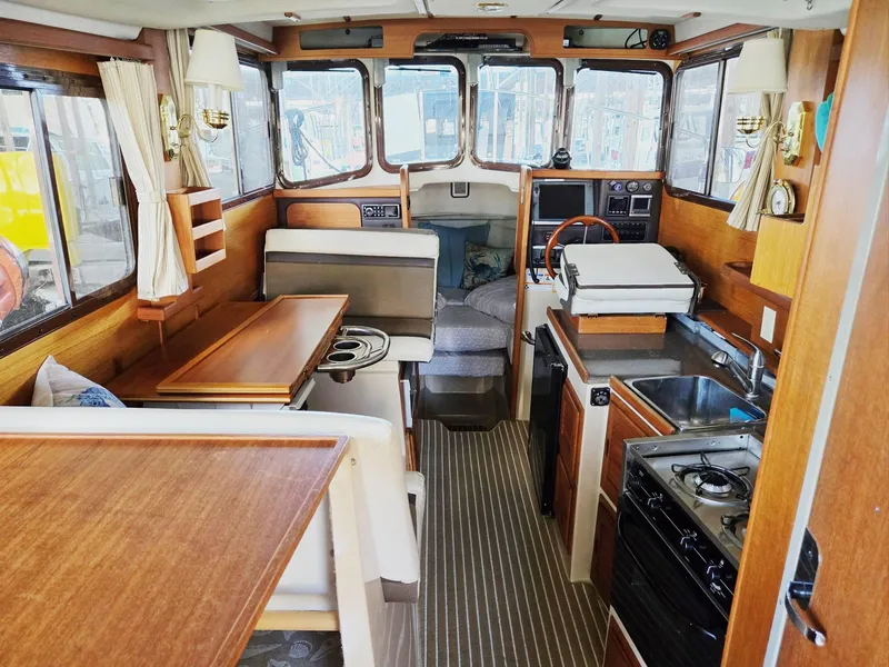 Slide: The Image of Interior of 2014 Ranger Tugs R-27 boat with kitchen, seating, and helm. - 22
