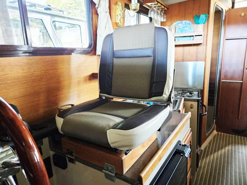 Slide: The Image of Interior of 2014 Ranger Tugs R-27 boat with captain's chair and kitchenette. - 26