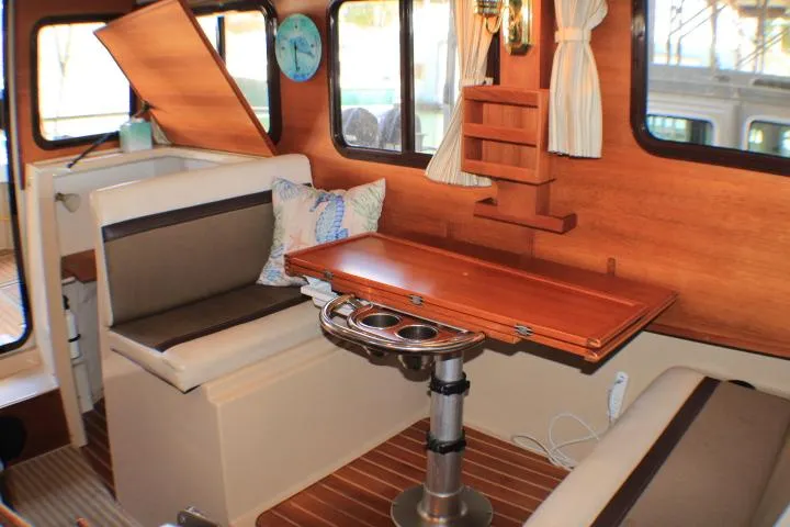 Slide: The Image of Interior of 2014 Ranger Tugs R-27 boat with wooden table and seating area. - 32