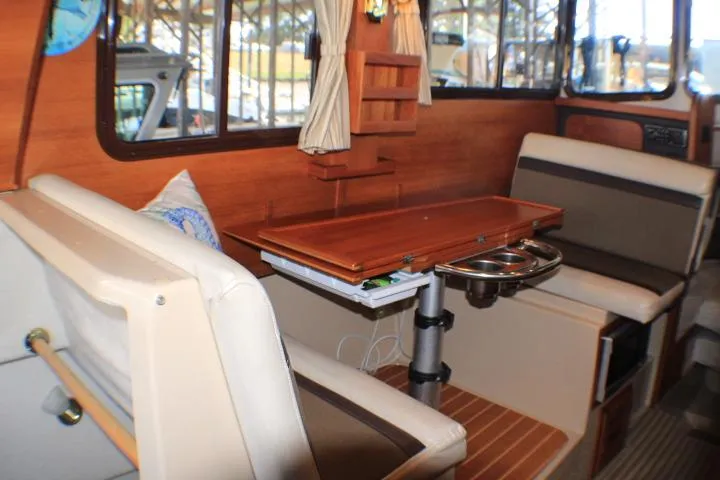 Slide: The Image of Interior of 2014 Ranger Tugs R-27 boat with wooden table and seating area. - 34