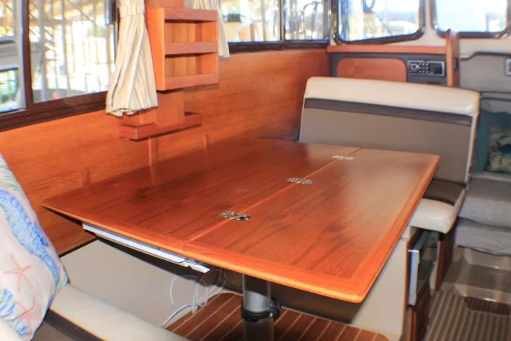 Slide: The Image of Interior of 2014 Ranger Tugs R-27 boat with wooden dining table and seating area. - 35