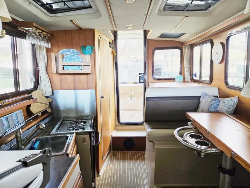 Slide: The Image of Interior of 2014 Ranger Tugs R-27 boat featuring kitchen and seating area. - 37