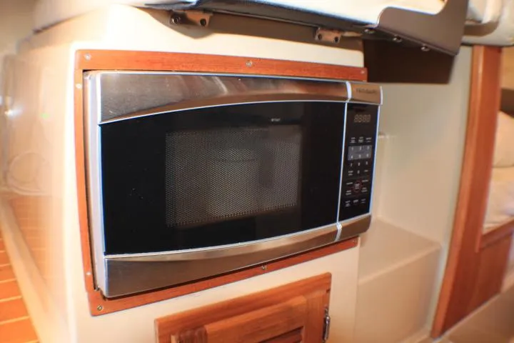 Slide: The Image of Microwave in 2014 Ranger Tugs R-27 boat interior, featuring wood paneling. - 41