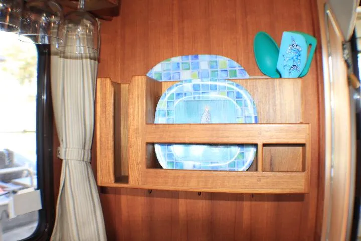 Slide: The Image of Wooden shelf with colorful plates and cups in a 2014 Ranger Tugs R-27 boat interior. - 42