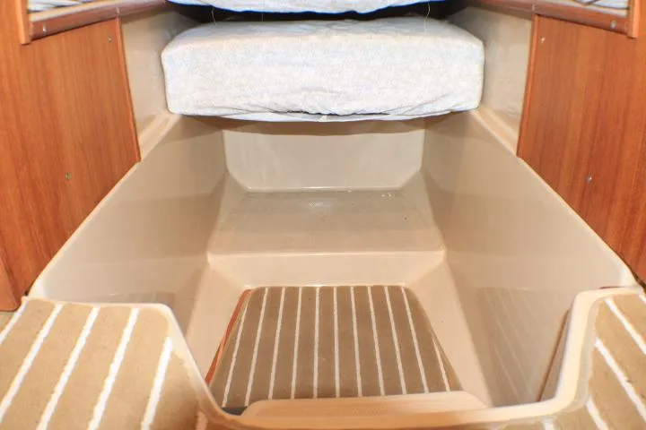 Slide: The Image of 2014 Ranger Tugs R-27 interior cabin with wooden accents and cushioned seating. - 44