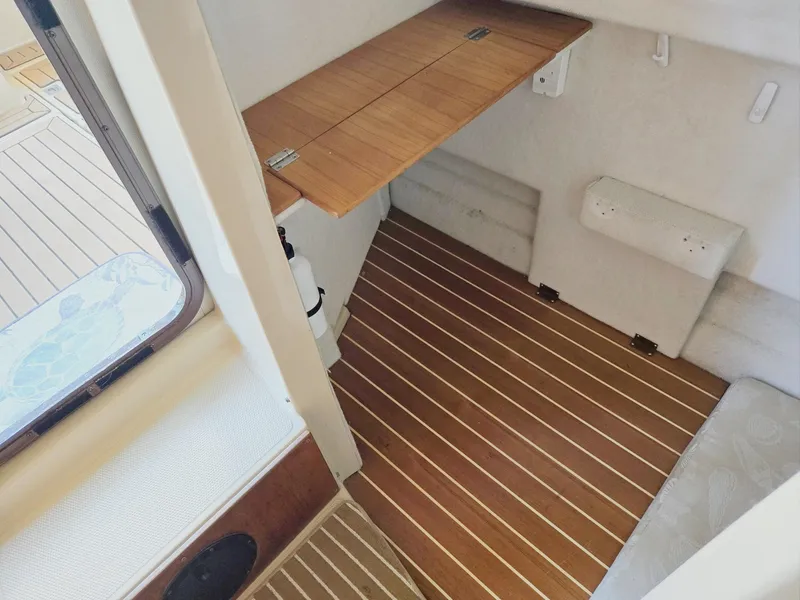 Slide: The Image of 2014 Ranger Tugs R-27 interior with wooden flooring and foldable table. - 48