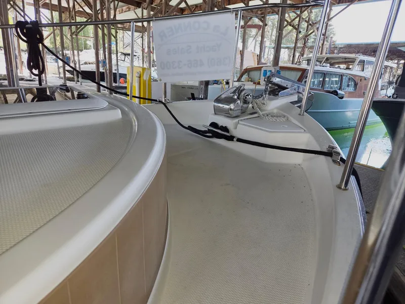 Slide: The Image of 2014 Ranger Tugs R-27 boat docked in a marina, showcasing deck and railing. - 9