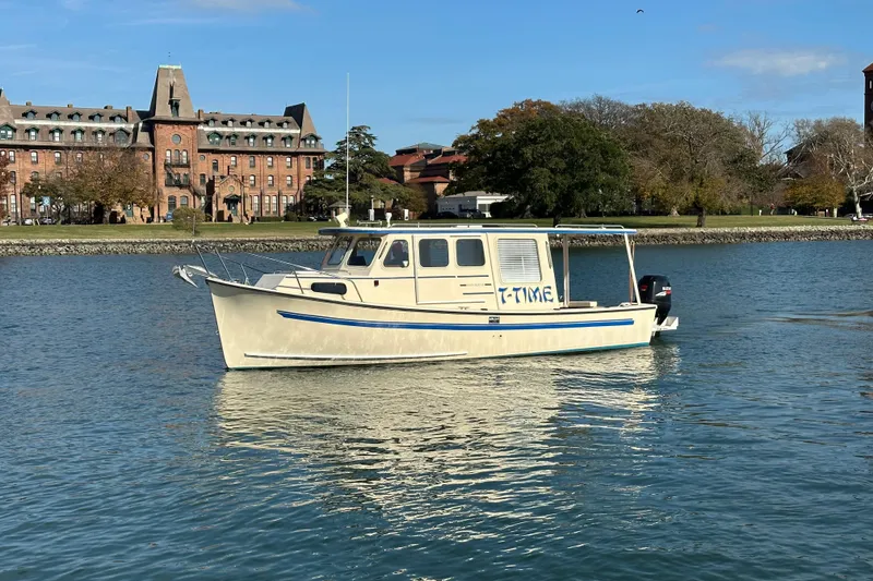 Slide: The Image of A 2000 Rosborough 246LVS boat on calm water with a scenic island background. - 0