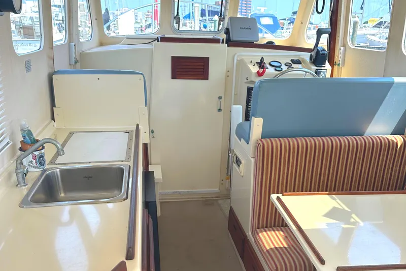 Slide: The Image of Interior of 2000 Rosborough 246LVS boat with red cushions and wooden cabinet. - 15
