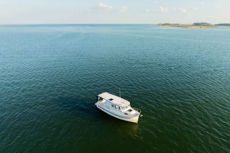 Slide: The Image of 2000 Rosborough 246LVS boat on calm water with scenic island background. - 38