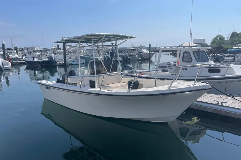 Slide: The Image of A 1995 Parker 21 CC boat docked in a marina under a clear blue sky. - 10