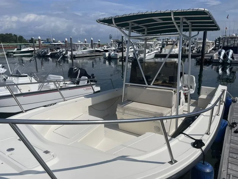 Slide: The Image of 1995 Parker 21 CC boat docked at marina, featuring open deck and canopy. - 3