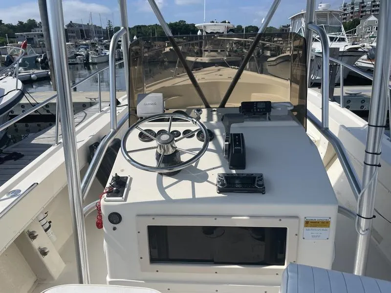 Slide: The Image of 1995 Parker 21 CC boat dashboard with steering wheel and controls at marina. - 4