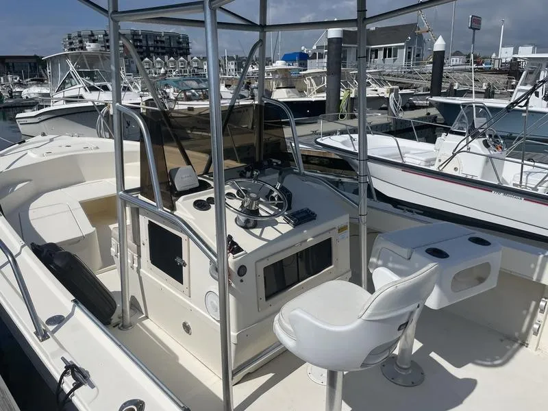 Slide: The Image of 1995 Parker 21 CC boat with steering console, docked in a marina. - 5