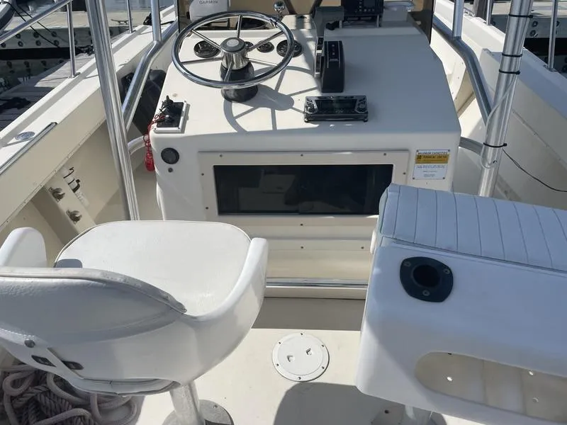 Slide: The Image of Cockpit of a 1995 Parker 21 CC boat with steering wheel and seating. - 7