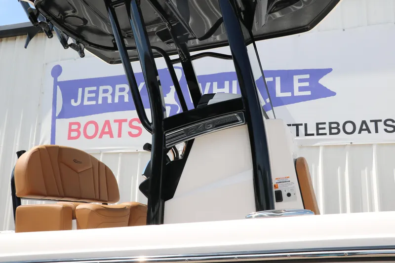Slide: The Image of 2025 Robalo 246 Cayman boat with tan seats and black console, displayed at dealership. - 13