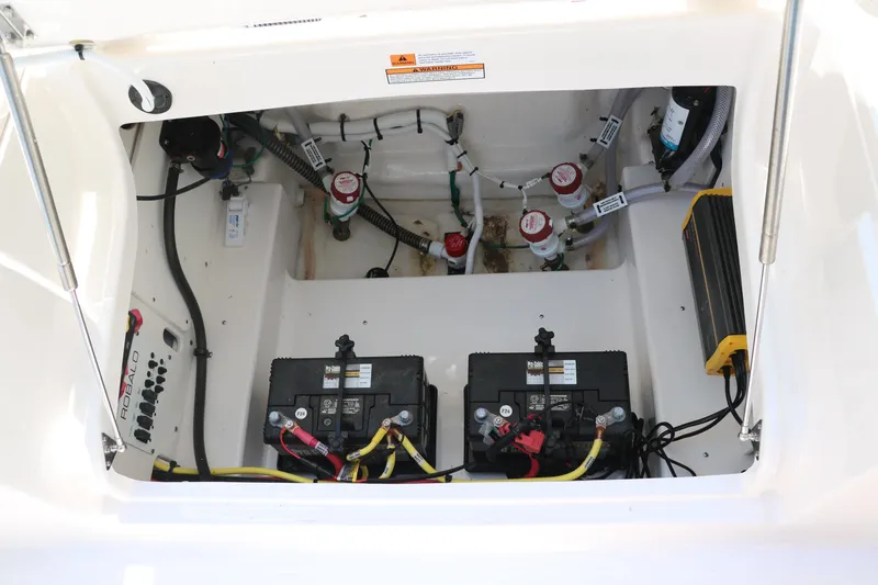 Slide: The Image of 2025 Robalo 246 Cayman boat battery compartment with wiring and components. - 30