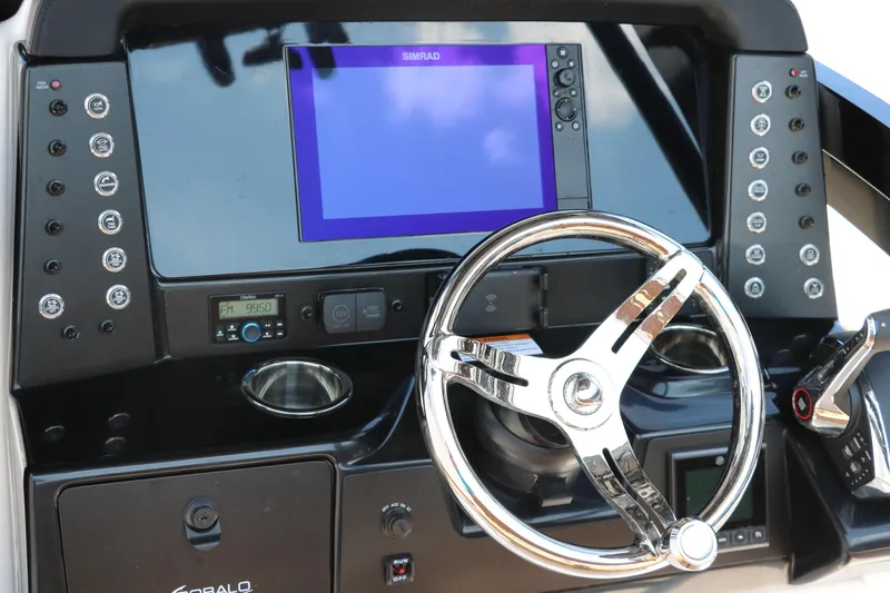 Slide: The Image of 2025 Robalo 246 Cayman boat dashboard with steering wheel and electronic controls. - 33