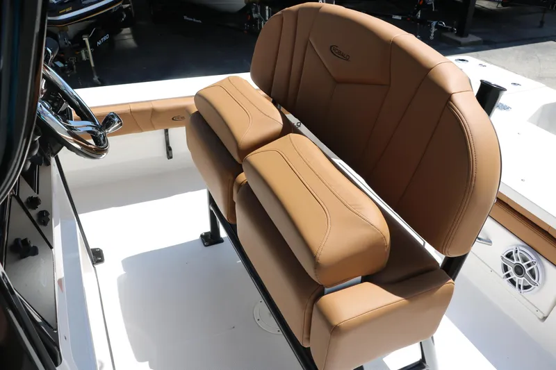 Slide: The Image of 2025 Robalo 246 Cayman boat interior with tan leather seating and steering wheel. - 34