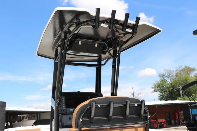 Slide: The Image of 2025 Robalo 246 Cayman boat with T-top and rod holders under a clear blue sky. - 8