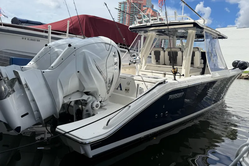 Slide: The Image of 2022 Pursuit S 358 Sport boat on turquoise water with person waving. - 0