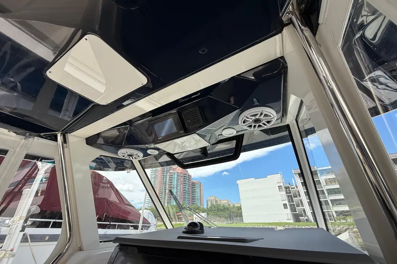 Slide: The Image of 2022 Pursuit S 358 Sport boat interior with storage compartments and control panel. - 24
