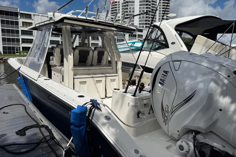 Slide: The Image of 2022 Pursuit S 358 Sport boat with dual outboard engines docked in marina. - 4
