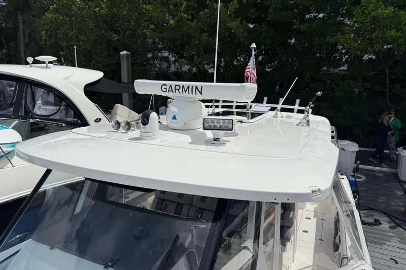 Slide: The Image of 2022 Pursuit S 358 Sport boat docked near modern buildings and American flag. - 46