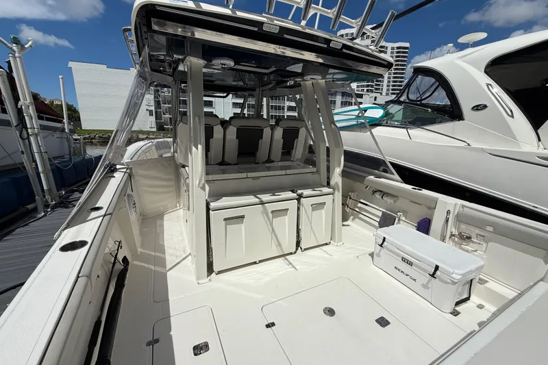 Slide: The Image of 2022 Pursuit S 358 Sport boat docked, featuring dual outboard engines and modern design. - 6