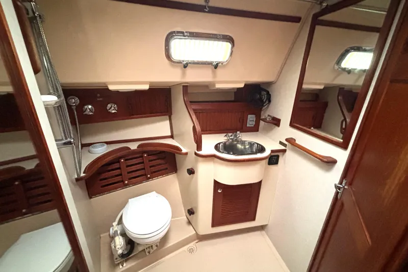 Slide: The Image of 2001 Island Packet 380 yacht bathroom with sink, toilet, and wooden accents. - 12