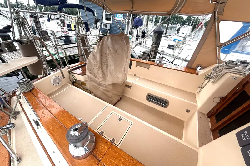 Slide: The Image of 2001 Island Packet 380 sailboat cockpit with wooden trim and covered helm, docked at marina. - 20