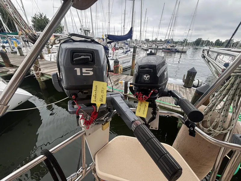 Slide: The Image of Two outboard motors on a 2001 Island Packet 380 sailboat at a marina. - 22