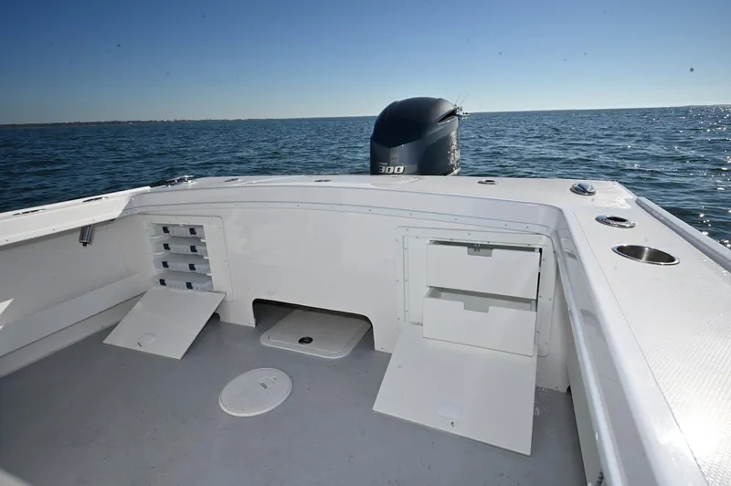 Slide: The Image of 2026 Steiger Craft 255 Tournament boat with open storage, ocean backdrop, and powerful outboard motor. - 8