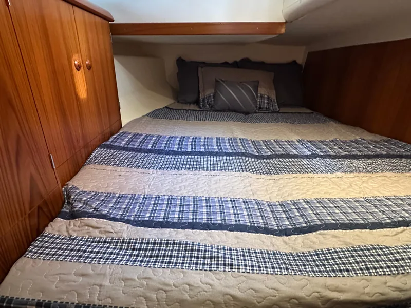 Slide: The Image of Cozy cabin interior of 2000 Jeanneau Sun Odyssey 45.2 with striped bedding and wooden cabinetry. - 11