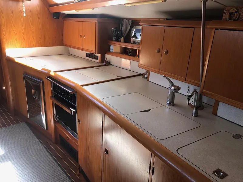 Slide: The Image of Interior of 2000 Jeanneau Sun Odyssey 45.2 yacht kitchen with wooden cabinets and modern appliances. - 13