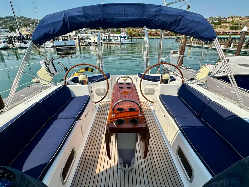 Slide: The Image of Jeanneau Sun Odyssey 45.2 yacht cockpit with dual steering wheels and blue seating, docked in marina. - 35