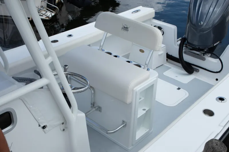 Slide: The Image of 2026 Steiger Craft 23 Tournament boat interior with seating and motor, docked on water. - 9