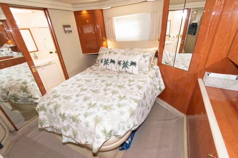 Slide: The Image of Luxurious 2000 Sea Ray 420 Aft Cabin bedroom with tropical-themed bedding and elegant wood finishes. - 17