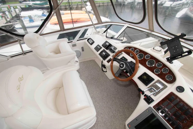 Slide: The Image of Luxurious helm of 2000 Sea Ray 420 Aft Cabin yacht with plush seating and advanced controls. - 8