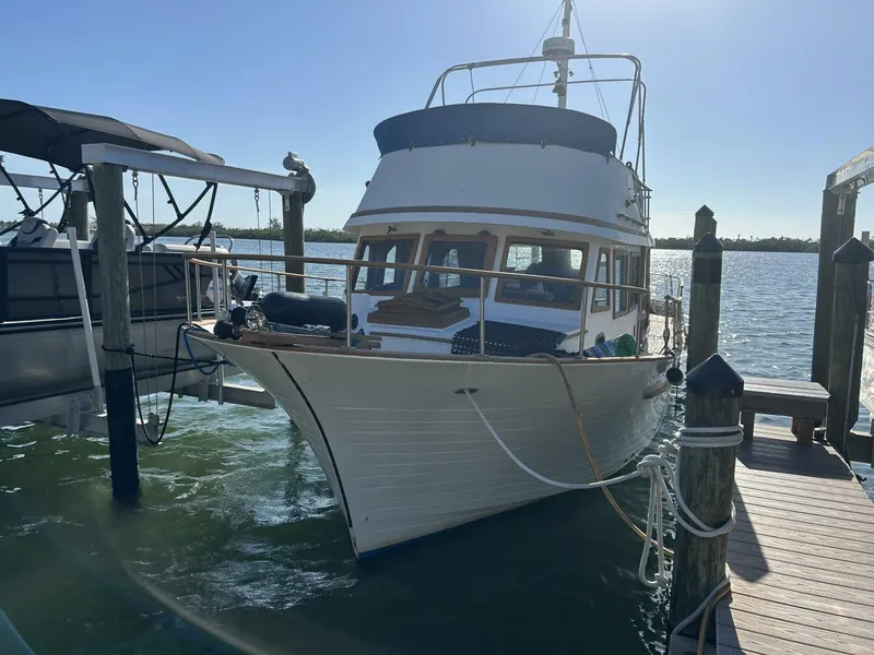 The Image of 1978 Albin 36 Trawler docked at a marina under clear blue skies. - 0