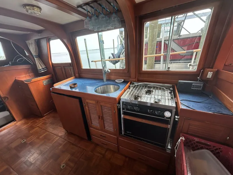Slide: The Image of Interior of 1978 Albin 36 Trawler kitchen with stove, sink, and wooden cabinetry. - 14