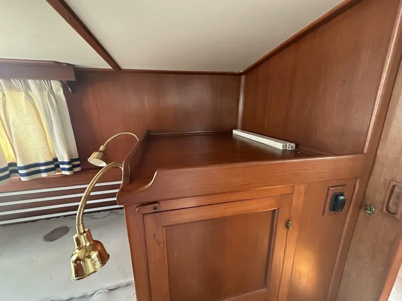 Slide: The Image of 1978 Albin 36 Trawler interior with wooden cabinetry and brass lamp. - 23