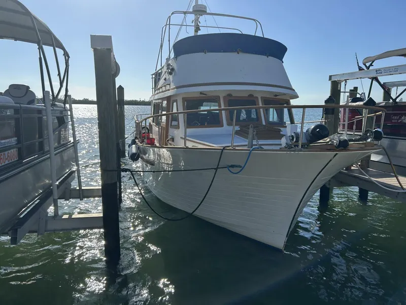 Slide: The Image of 1978 Albin 36 Trawler docked in sunny marina, reflecting on water. - 3
