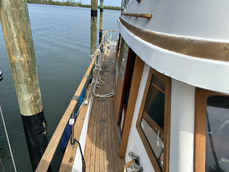 Slide: The Image of 1978 Albin 36 Trawler docked, showcasing wooden deck and cabin details. - 41