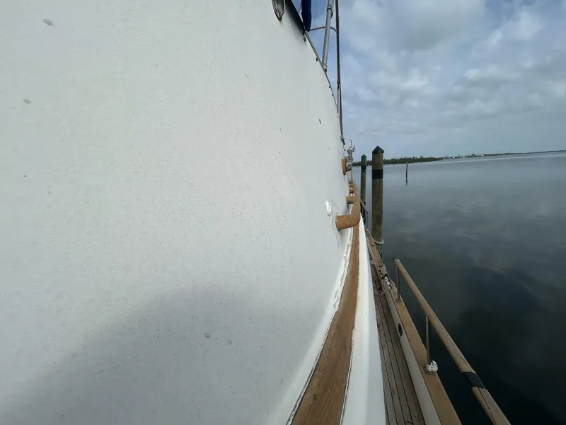 Slide: The Image of Side view of a 1978 Albin 36 Trawler docked by calm waters. - 44